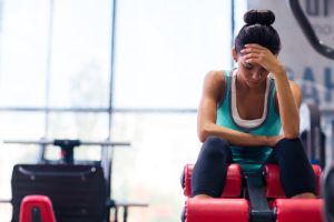 tired woman sitting on exercise machine