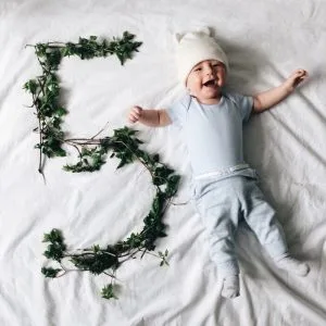 11 Unique Ways To Capture Baby Milestones In Pictures 5 baby smiling with a number