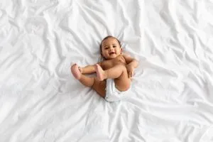 11 Unique Ways To Capture Baby Milestones In Pictures 2 top view of little black baby lying on bed at home 2021 09 02 22 25 15 utc scaled 1