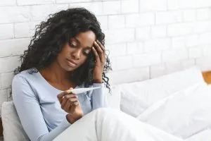 girl taking temperature in bed